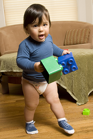 Toddler walking with toys.